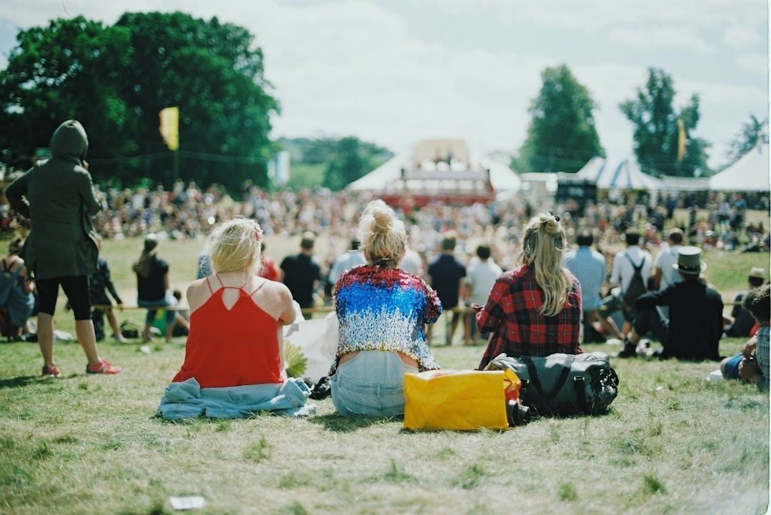 Crowd gathered on a grassy field at an outdoor music festival