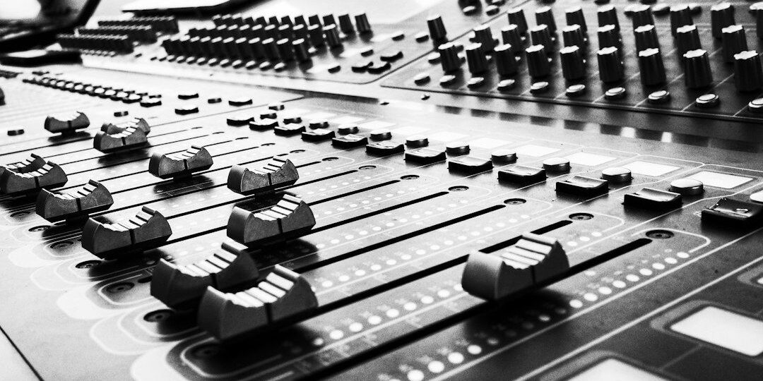 Close-up black-and-white view of a professional audio mixing console