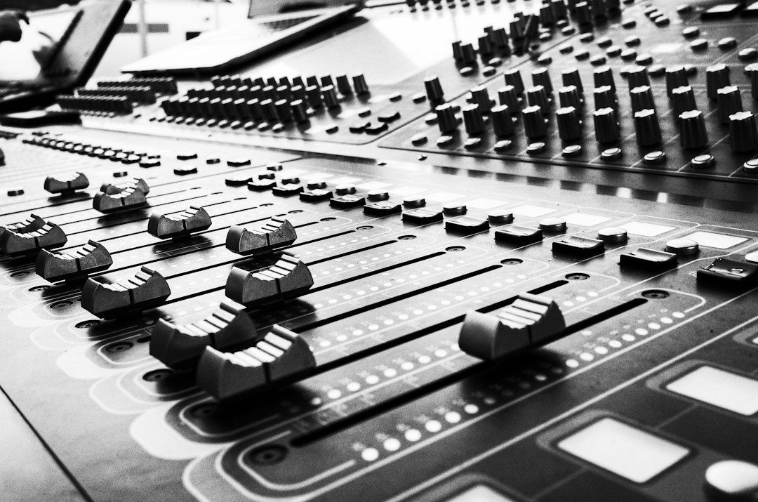 Close-up black-and-white view of a professional audio mixing console